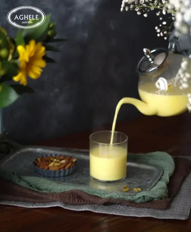 شیر زعفران که از داخل قوری در حال ریخته شدن داخل لیوان است.